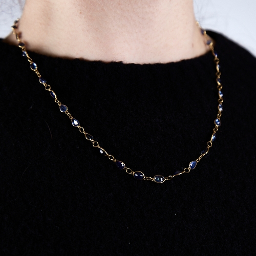 1287 - A modern handmade unmarked high carat gold sapphire line necklace, set with oval and pear-cut sapphi... 