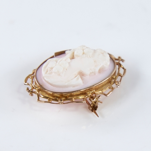 1303 - An early 20th century relief carved pink coral cameo brooch/pendant, depicting Classical female prof... 