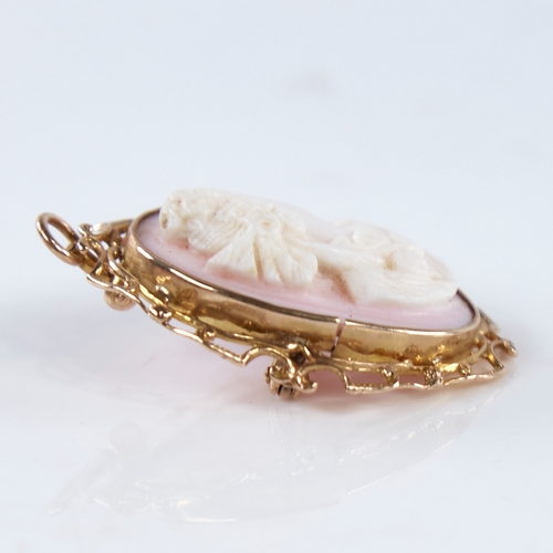 1303 - An early 20th century relief carved pink coral cameo brooch/pendant, depicting Classical female prof... 