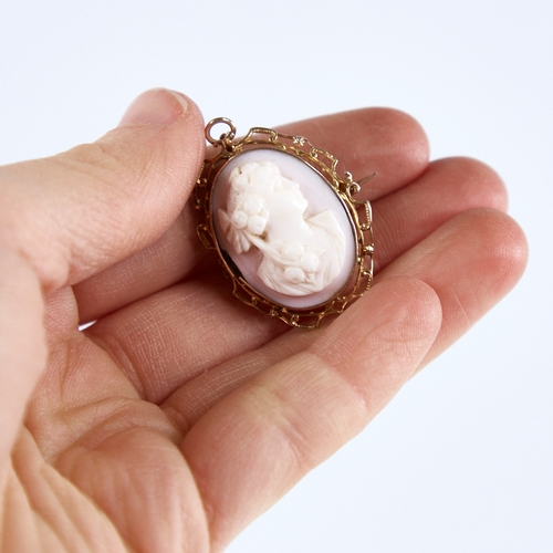 1303 - An early 20th century relief carved pink coral cameo brooch/pendant, depicting Classical female prof... 