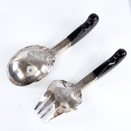 1306 - A pair of Middle Eastern unmarked silver horn-handled salad servers, pierced and engraved floral dec... 