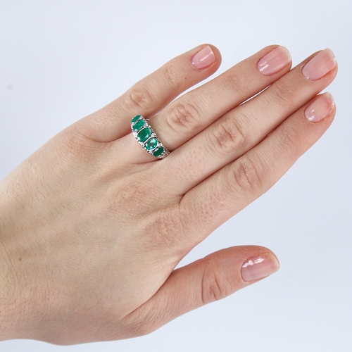 1307 - A modern 14ct white gold graduate 5-stone emerald and diamond half hoop ring, set with oval-cut emer... 