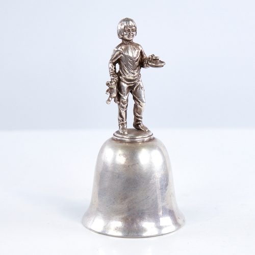 1319 - A late 20th century unmarked white metal dinner bell, figural design handle depicting boy with teddy... 