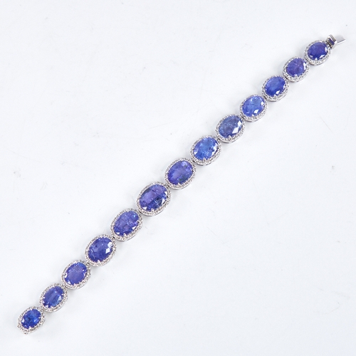 1329 - A modern platinum tanzanite and diamond cluster line bracelet, set with graduated panels of oval-cut... 