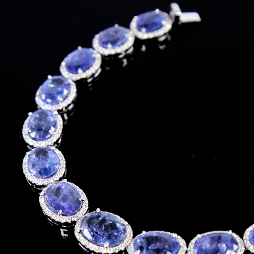 1329 - A modern platinum tanzanite and diamond cluster line bracelet, set with graduated panels of oval-cut... 