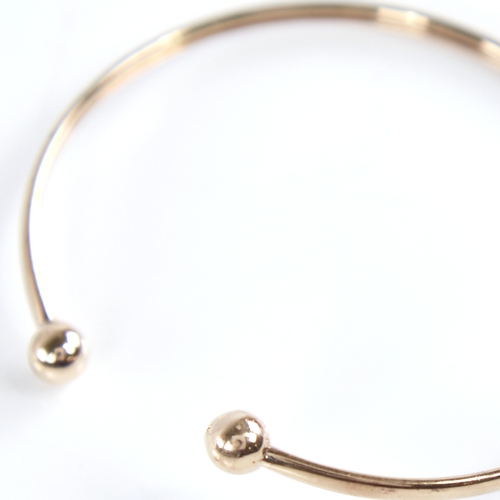 1335 - An unmarked gold torque bangle, tests as 9ct, band width 2.5mm, internal length 53mm, internal heigh... 