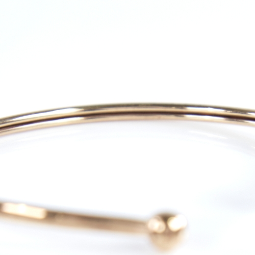 1335 - An unmarked gold torque bangle, tests as 9ct, band width 2.5mm, internal length 53mm, internal heigh... 