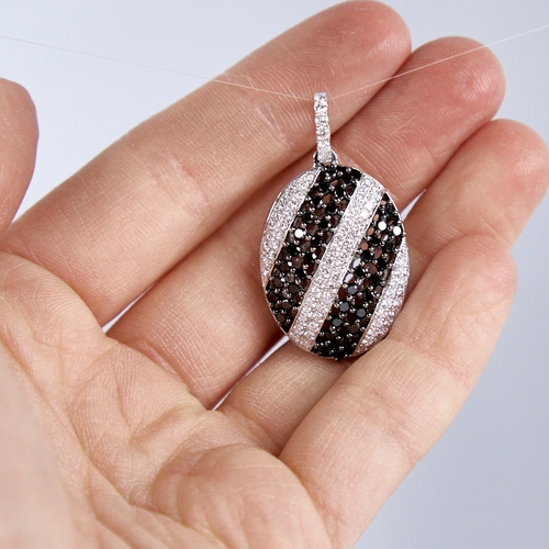 1337 - A modern 18ct white gold black and white diamond pendant, set with alternating stripes of round bril... 