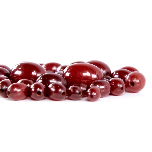 1344 - A group of loose cherry amber beads, bead lengths ranging from 24mm to 11mm, 55.2g total