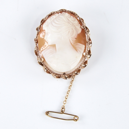 1369 - A mid-20th century relief carved shell cameo brooch, depicting female profile, in 9ct gold twist fra... 