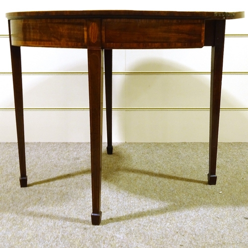 235 - A George III mahogany demilune fold over card table, with tapered legs and spade feet