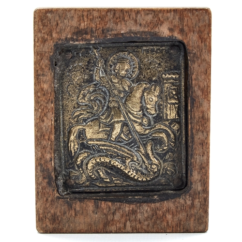 336 - A miniature Greek bronze relief cast icon depicting George and the Dragon, set in a stained wood alc... 