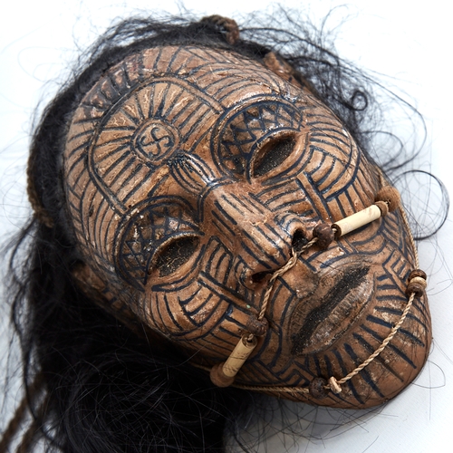 338 - An unusual composition Tribal head wall mask, with painted face and real hair, life-size, probably m... 