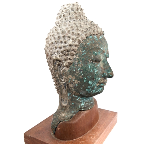 341 - A Chinese verdigris bronze Buddha head, probably 17th or 18th century, mounted on modern woodblock p... 