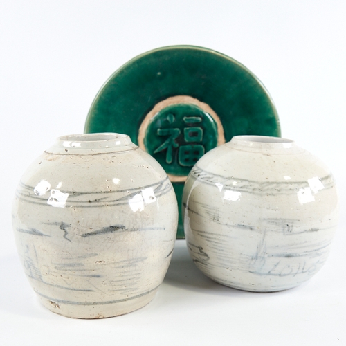 347 - A Chinese green glaze pottery bowl with central text panel, diameter 24cm, and a pair of blue and wh... 