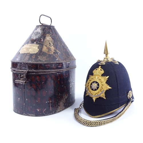 245 - East Surrey Regiment military helmet with gilt-brass crest and brass-mounted chin strap, in tin case