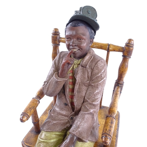 248 - An Austrian painted terracotta figure of a boy sitting in a stained wood spindle-back chair, no fact... 