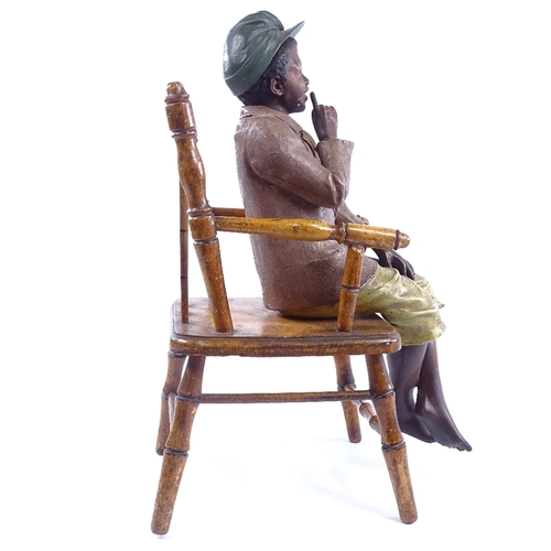 248 - An Austrian painted terracotta figure of a boy sitting in a stained wood spindle-back chair, no fact... 