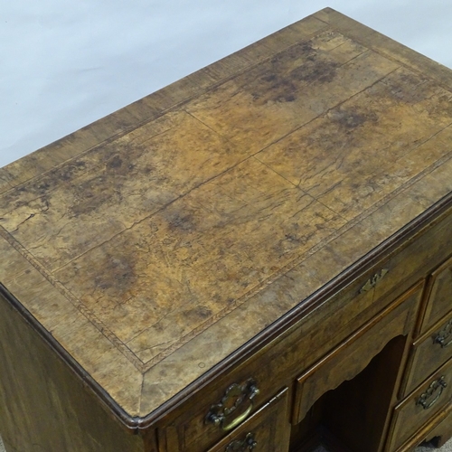 307 - A Georgian walnut kneehole desk of small size, quarter veneered and feather-banded top, with drawers... 