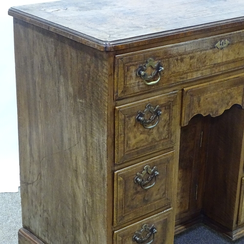 307 - A Georgian walnut kneehole desk of small size, quarter veneered and feather-banded top, with drawers... 