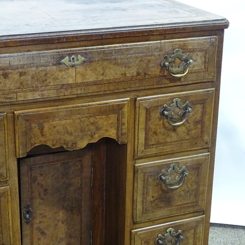 307 - A Georgian walnut kneehole desk of small size, quarter veneered and feather-banded top, with drawers... 