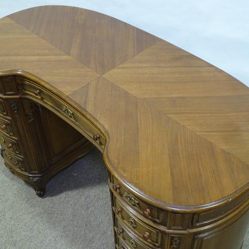 316 - A walnut kidney-shaped pedestal desk, mid-20th century, with shaped moulded panelled drawer fronts a... 