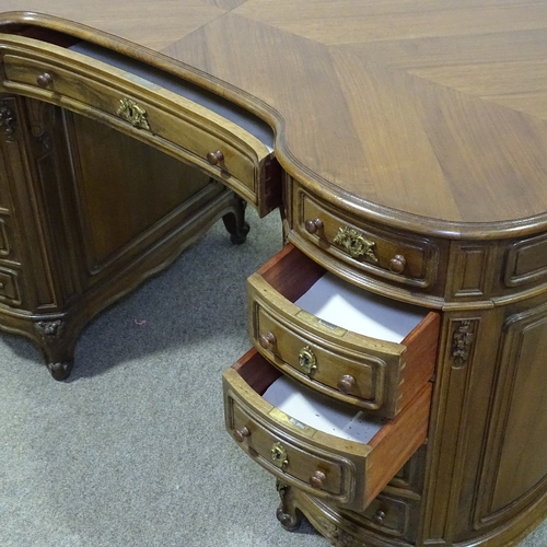 316 - A walnut kidney-shaped pedestal desk, mid-20th century, with shaped moulded panelled drawer fronts a... 