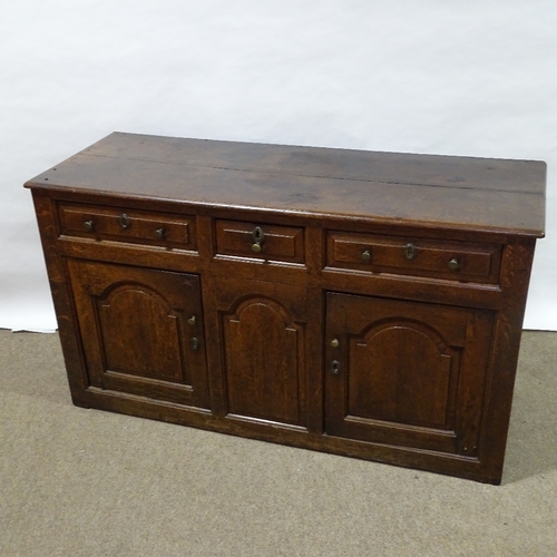 370 - An 18th century oak dresser base, with fielded panelled cupboards and frieze drawers, length 146cm, ... 