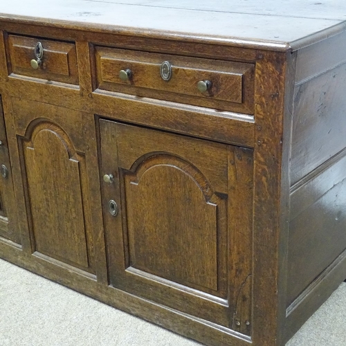 370 - An 18th century oak dresser base, with fielded panelled cupboards and frieze drawers, length 146cm, ... 