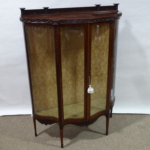 397 - An Edwardian mahogany serpentine-front display cabinet, with carved friezes and serpentine glass pan... 