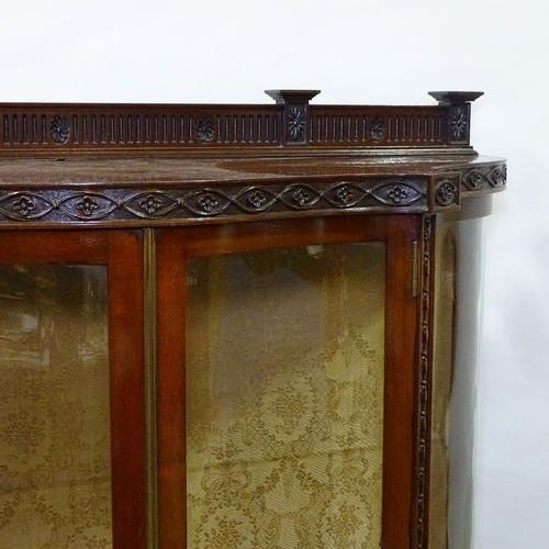 397 - An Edwardian mahogany serpentine-front display cabinet, with carved friezes and serpentine glass pan... 