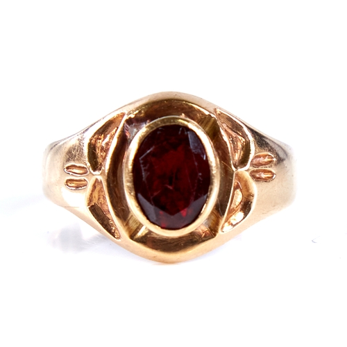 1672 - An 18ct gold garnet signet ring, set with oval mixed-cut garnet with decorated shoulders, setting he... 