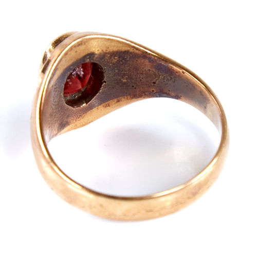 1672 - An 18ct gold garnet signet ring, set with oval mixed-cut garnet with decorated shoulders, setting he... 