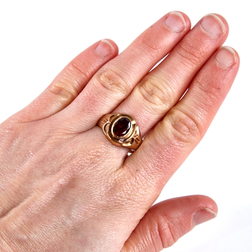 1672 - An 18ct gold garnet signet ring, set with oval mixed-cut garnet with decorated shoulders, setting he... 