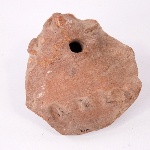 383 - An Ancient terracotta ocarina fragment with mask decoration, length 13cm, and a carved stone animal ... 