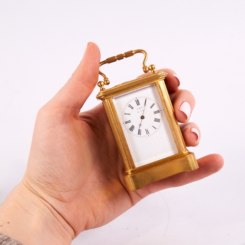 1055 - A 19th century miniature brass-cased carriage clock timepiece, white enamel dial with Roman numeral ... 