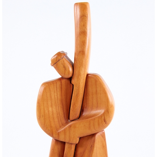 2156 - A modern stylised carved wood figure, of a man holding a staff, signed to foot, height 29cm.