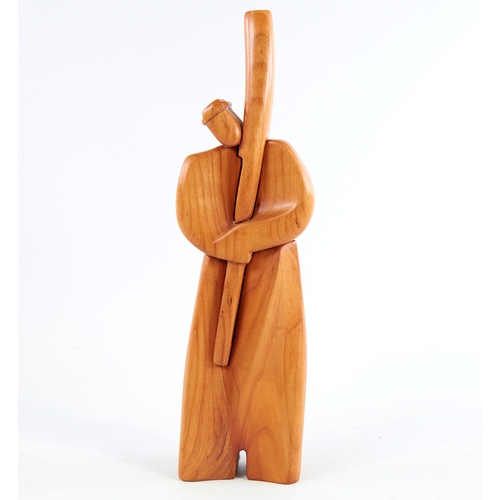 2156 - A modern stylised carved wood figure, of a man holding a staff, signed to foot, height 29cm.