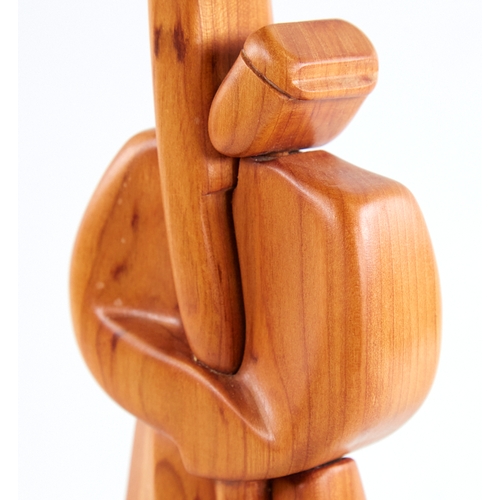 2156 - A modern stylised carved wood figure, of a man holding a staff, signed to foot, height 29cm.