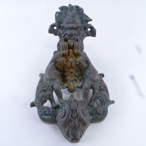 106 - A cast bronze door knocker, in Bacchanalian design, length 29cm, and a bronze lion mask door knocker... 