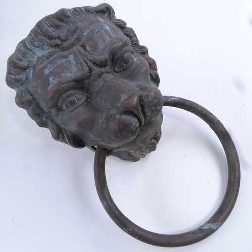 106 - A cast bronze door knocker, in Bacchanalian design, length 29cm, and a bronze lion mask door knocker... 