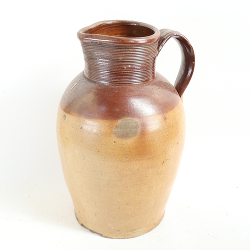 76 - A very large stoneware pottery jug, height 40cm (handle restored)