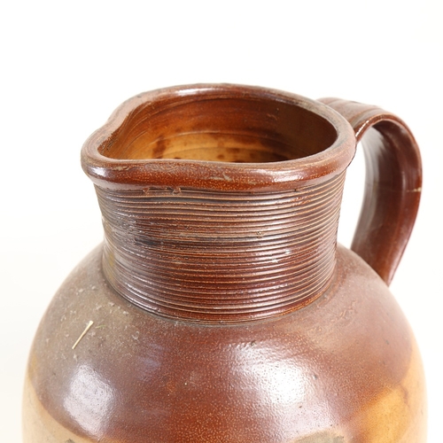 76 - A very large stoneware pottery jug, height 40cm (handle restored)