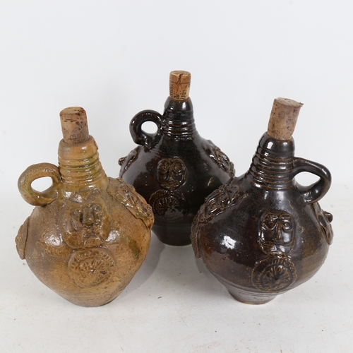 320 - 3 stoneware bottles with applied figure bosses, height 17cm