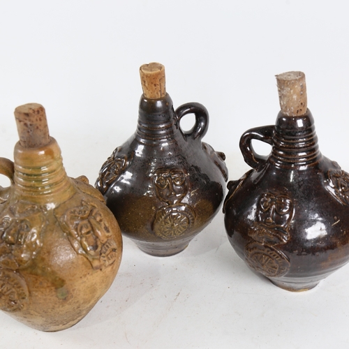 320 - 3 stoneware bottles with applied figure bosses, height 17cm