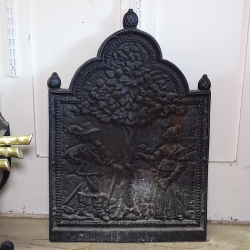 1858 - An Antique embossed cast-iron fireback, W49cm, H70cm and a ducks nest grate and fire irons