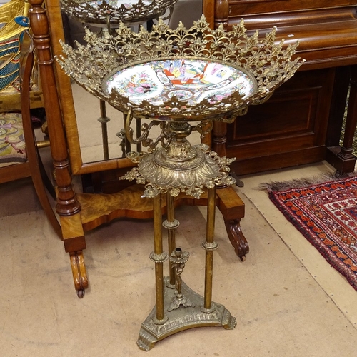 1885 - An ornate Oriental gilt-metal stand, having an inset Oriental ceramic dish, on turned supports and p... 