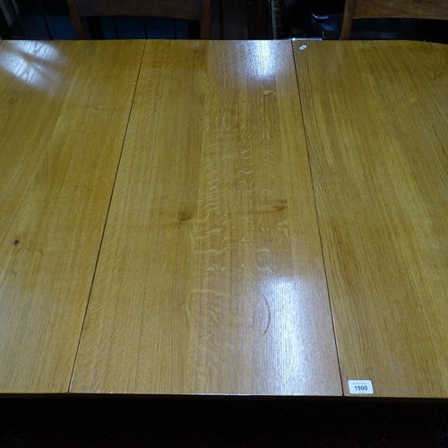 1900 - A modern golden oak bow-end extending dining table, with 2 spare leaves, on a chamfered leg base, L1... 