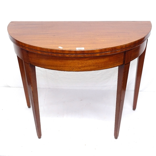 1912 - A 19th century mahogany demilune fold over card table, on square tapered legs