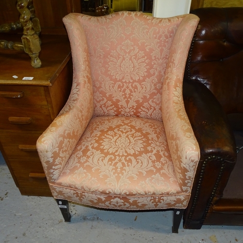 2099 - An Edwardian upholstered wing armchair, on tapered legs